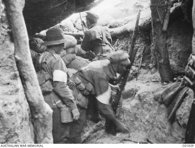 Three unidentified 7th Battalion men standing at a bomb stop at the old Turkish firing line in Lone Pine, Gallipoli. Note the pine logs remaining from the original trench headcover constructed by the Turks.